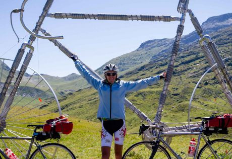 Biker posing with giant bicycle sculpture on French Alps to French Riviera tour