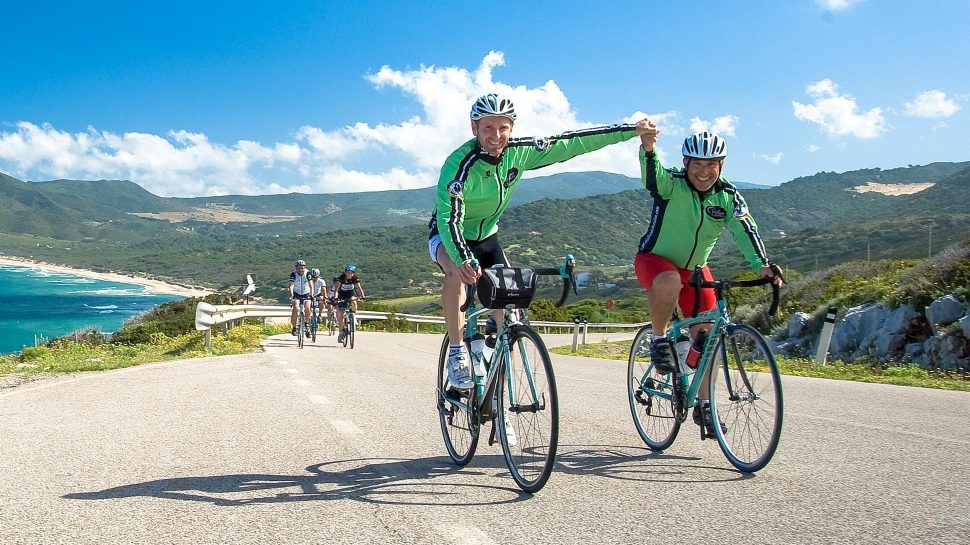 Bikers on the Mediterranean Island Hopping tour holding hands while biking