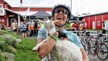 Biker holding a goat at the Farm to Fork event